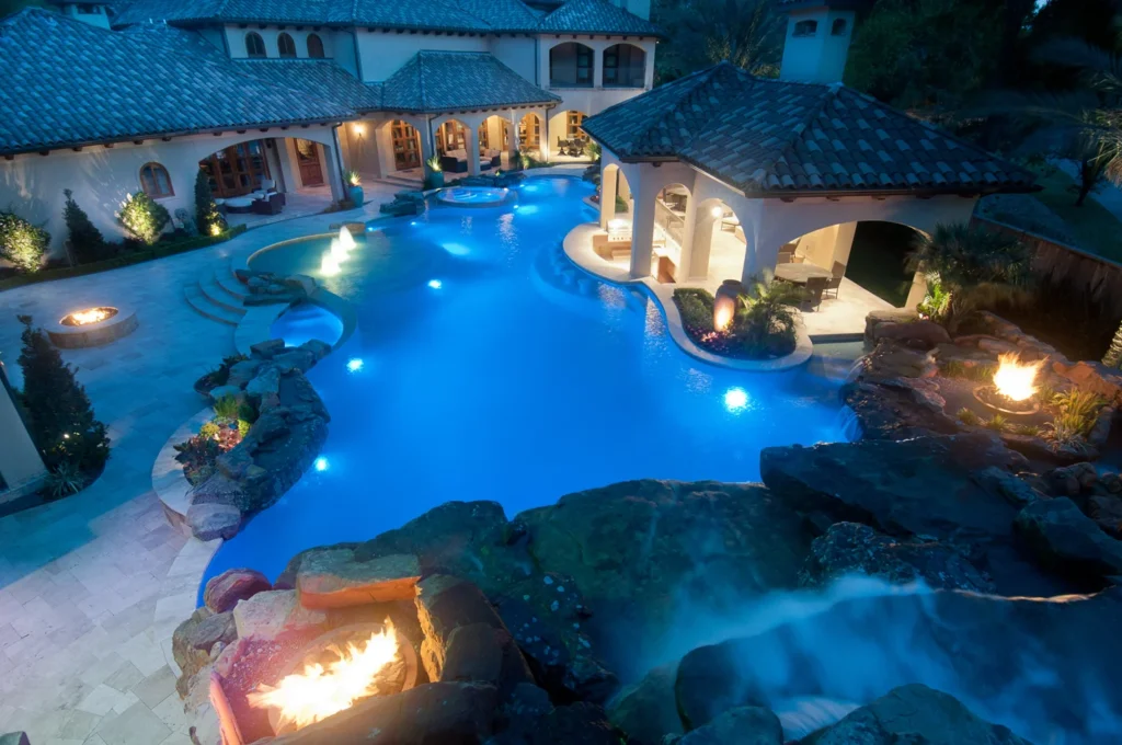 Entertainer’s estate outdoor living pool design with fire features and lighting in Houston Texas