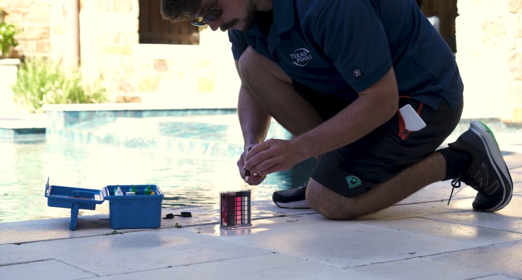 Pool technician using Taylor test kit for accurate chemical balancing in The Woodlands